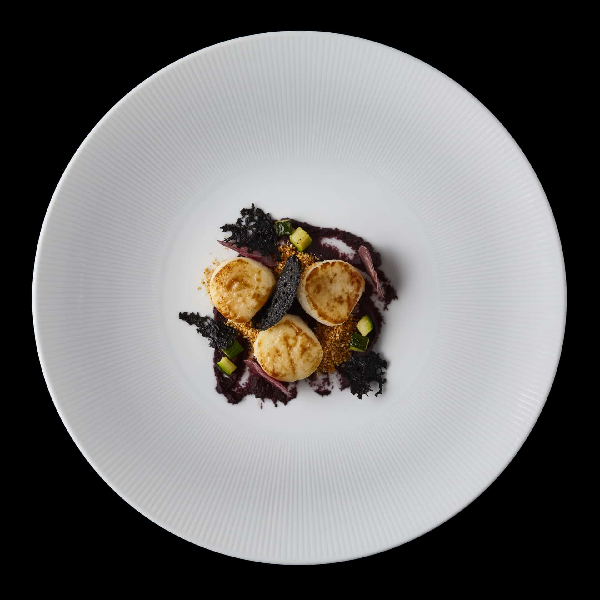 Grilled scallops with purple carrot puree and cuttlefish ink coral